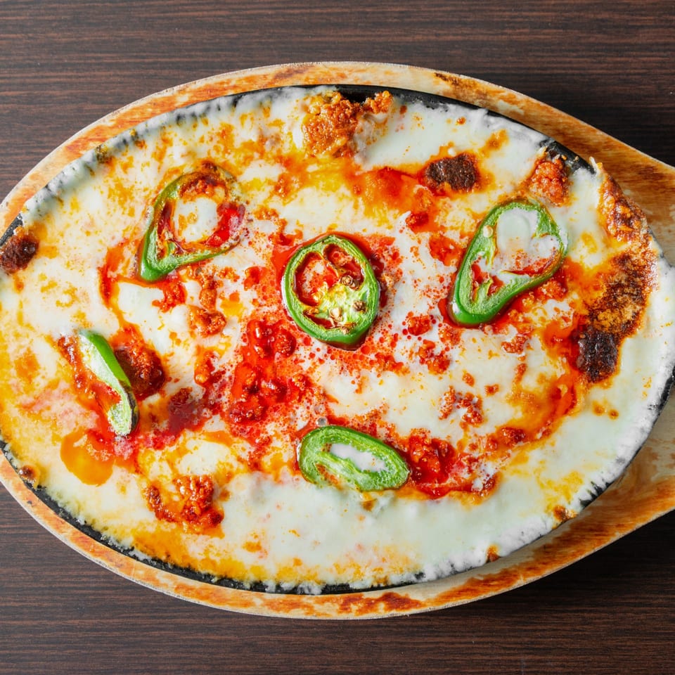 Melted cheese with jalapeno slices served in a skillet.