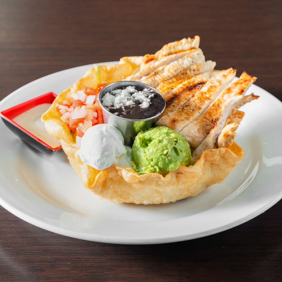 Tortilla shell salad with grilled chicken.