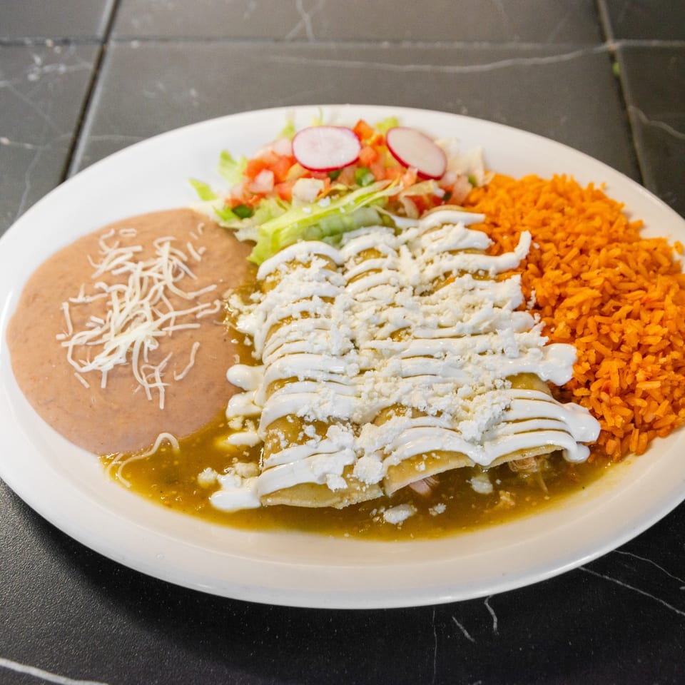 Enchiladas with green sauce, rice and refried beans.