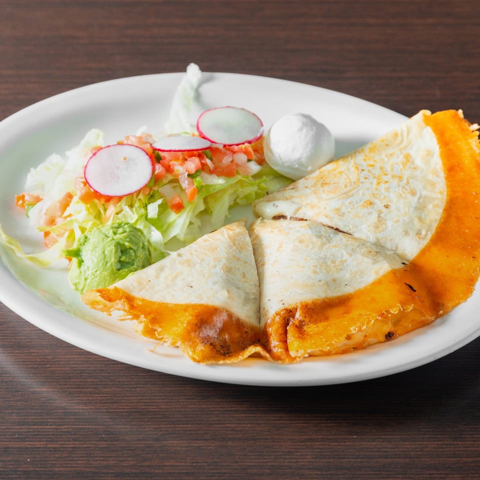 Quesadilla with salad, sour cream and guacamole.
