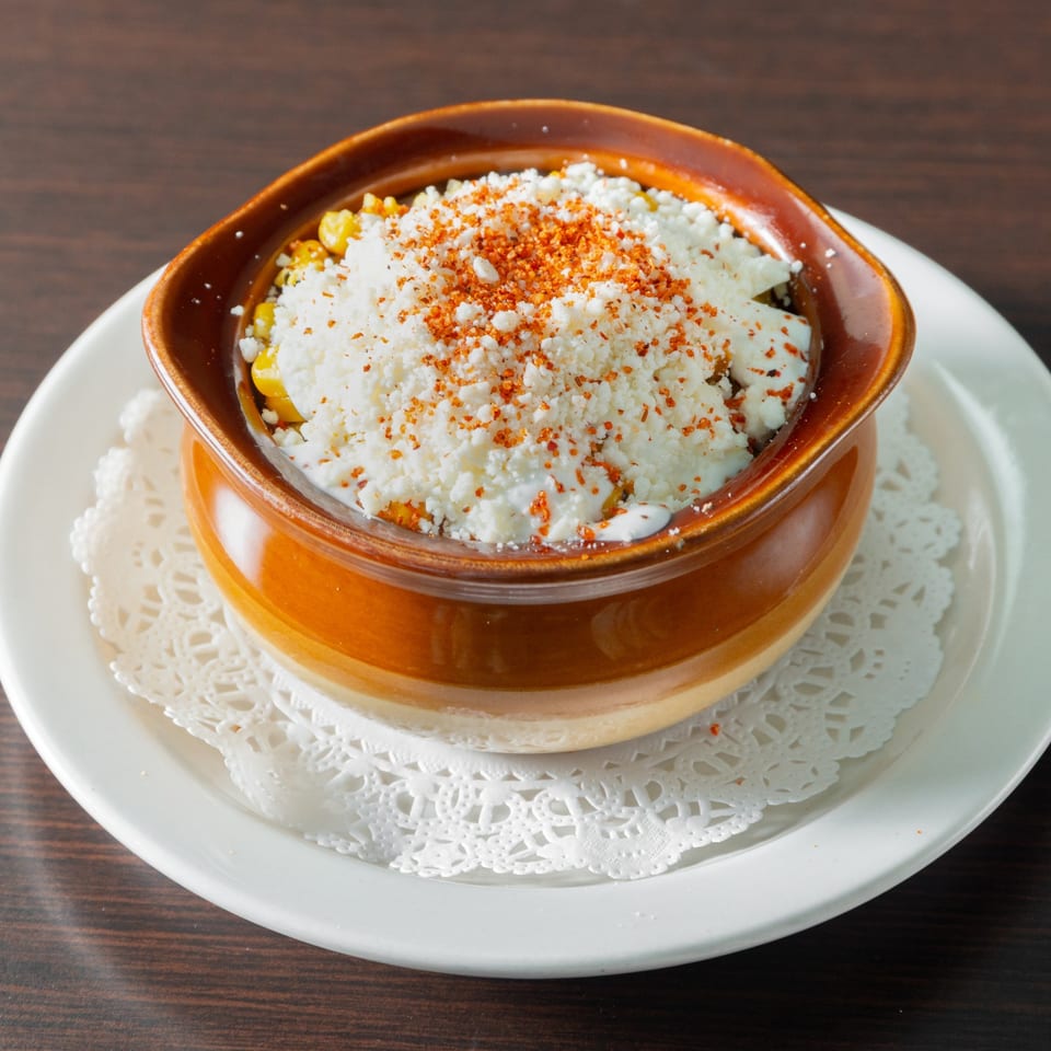 Corn topped with cheese, cream and seasoning.
