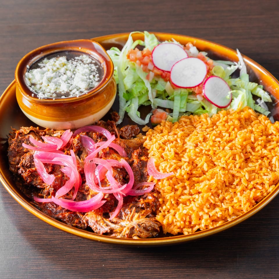 Marinated meat with pickled onions, rice, beans and salad.
